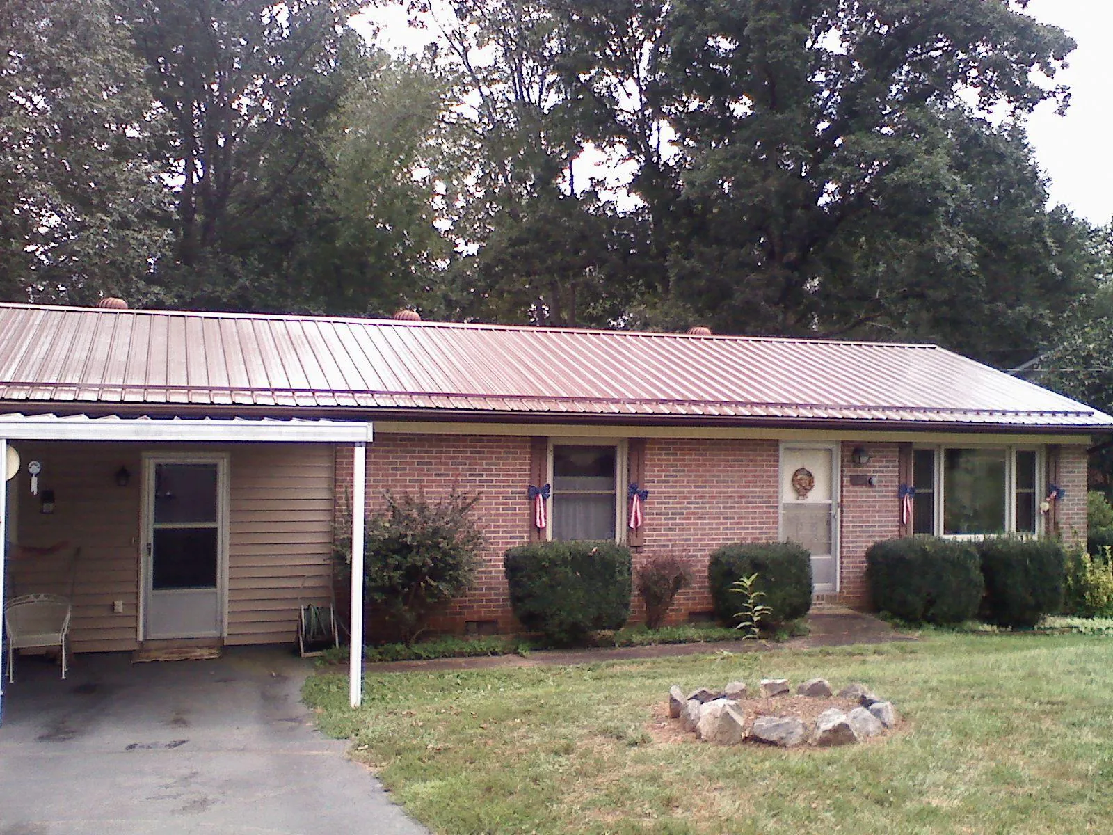 Bronze metal roof and carport on a brick ranch home — Roof Repair work by our crew in Hansville
